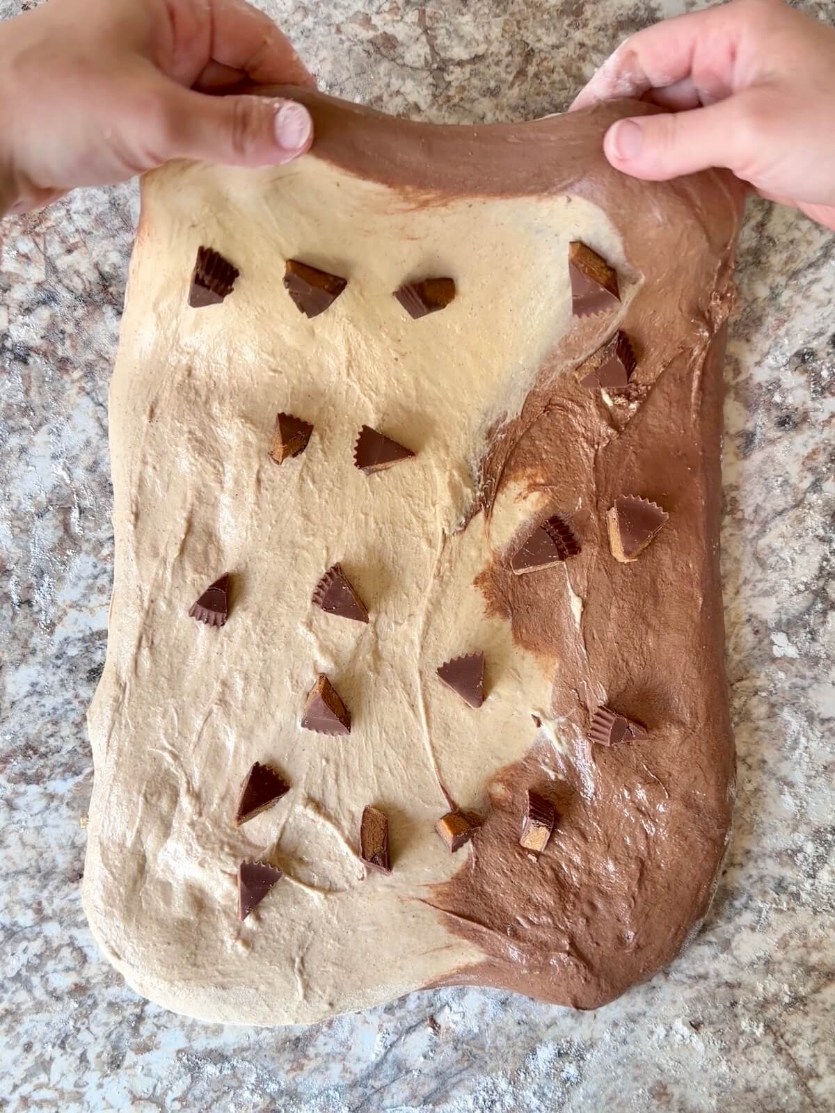 Reese's peanut butter cup pieces being added to the dough during shaping.
