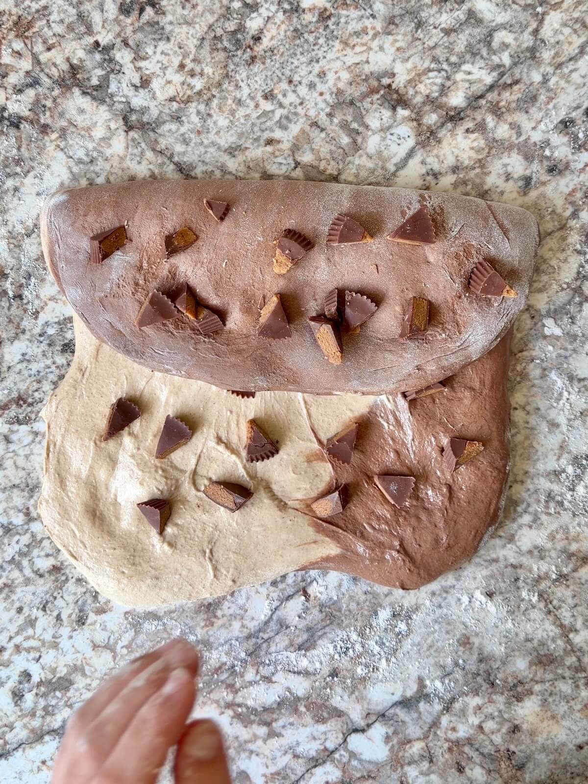 Reese's peanut butter cup pieces being added to the dough during shaping.