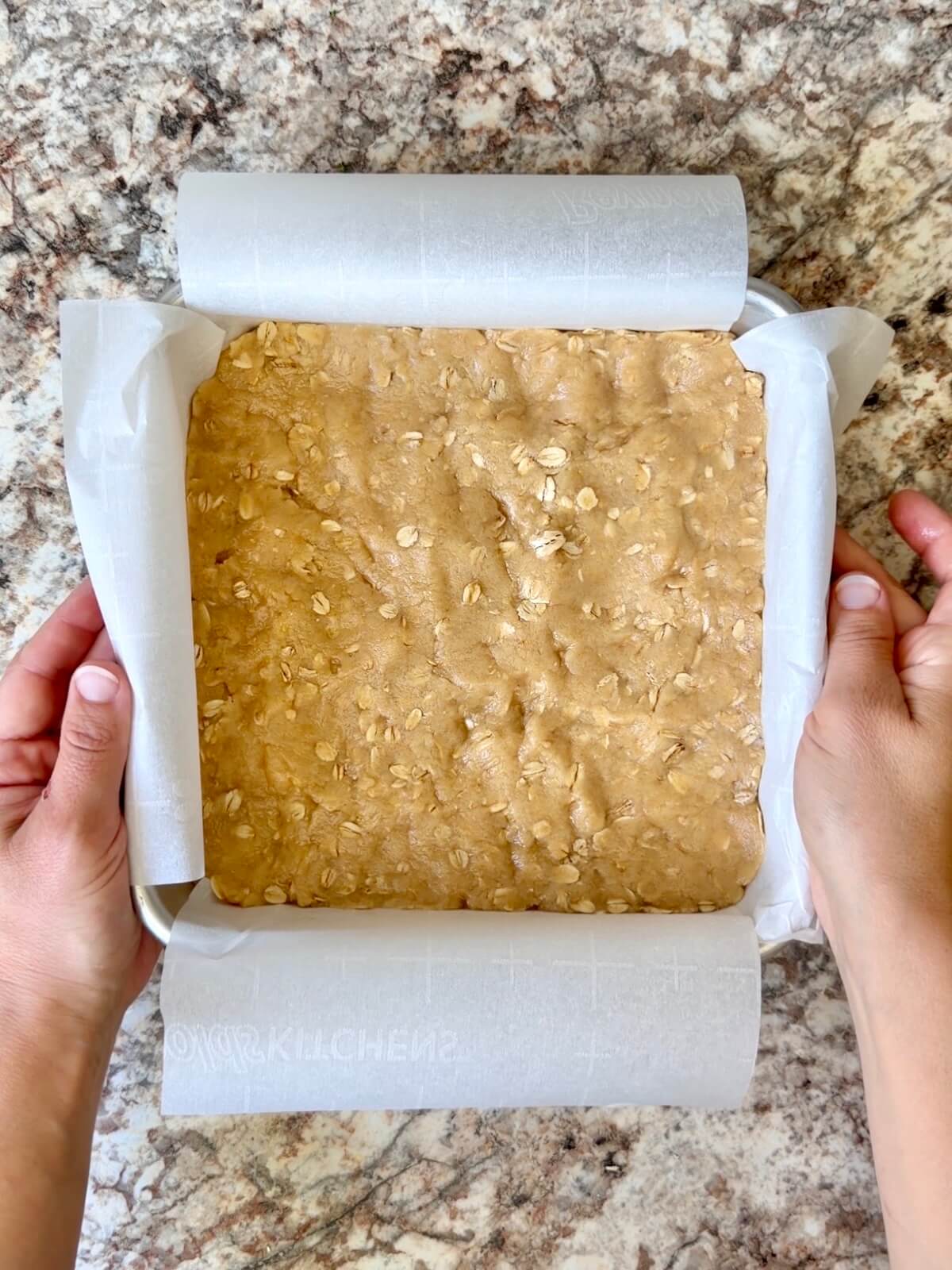 Sourdough discard oat crust pressed into a square aluminum baking pan.