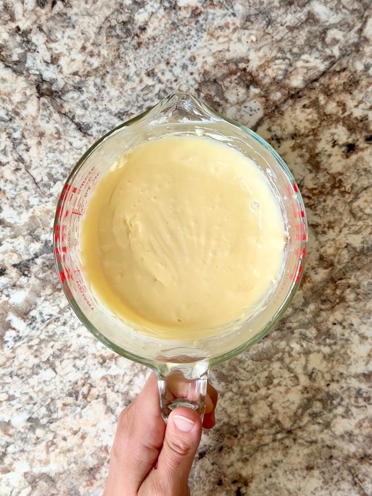 The cheesecake layer mixed in a glass bowl.