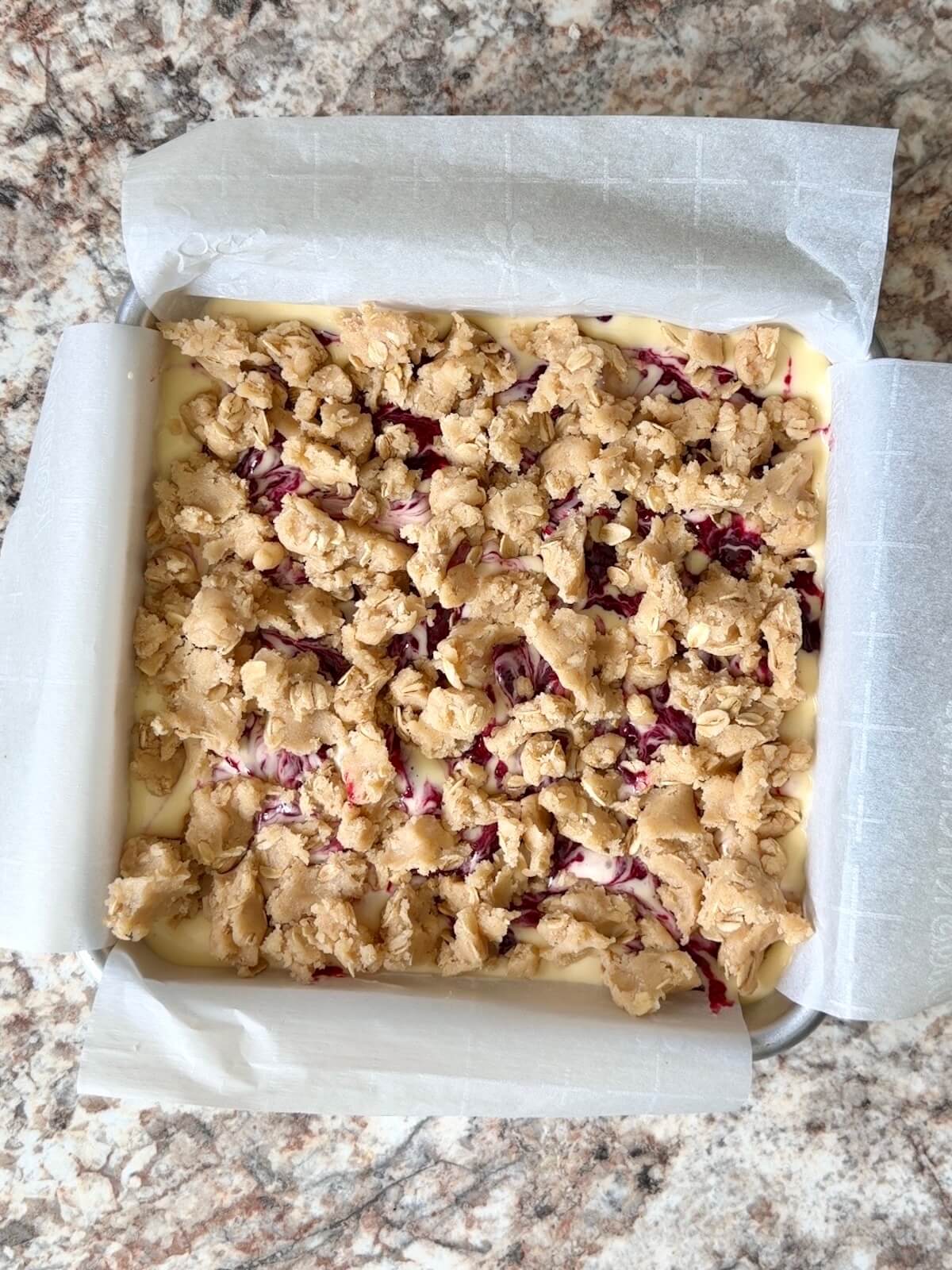 The remaining sourdough oat crumble on top of the raspberry cheesecake filling.