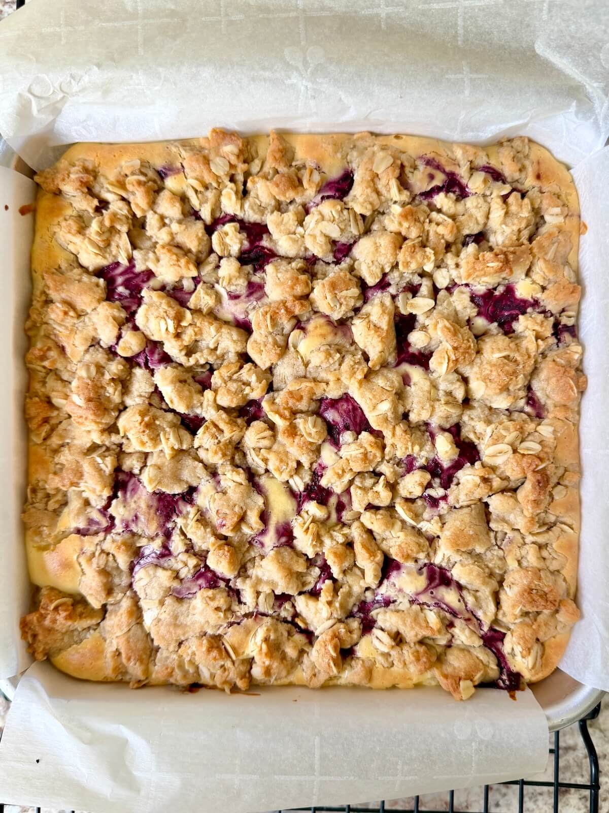 Baked sourdough raspberry cheesecake bars in a baking pan.