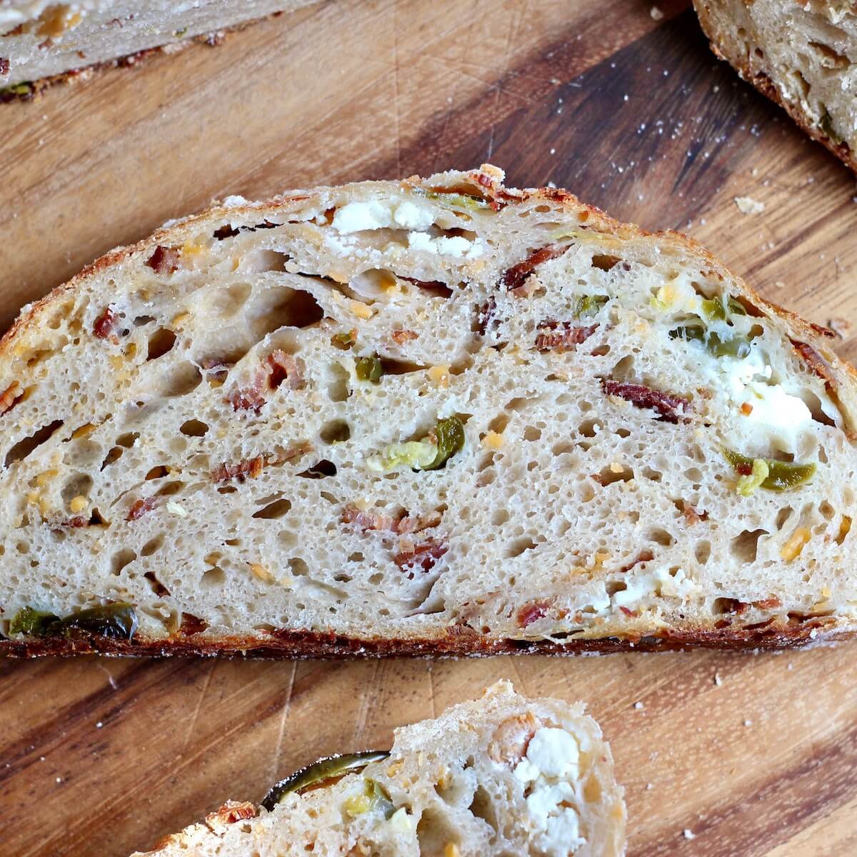 A slice of jalapeño popper sourdough bread on a cutting board.