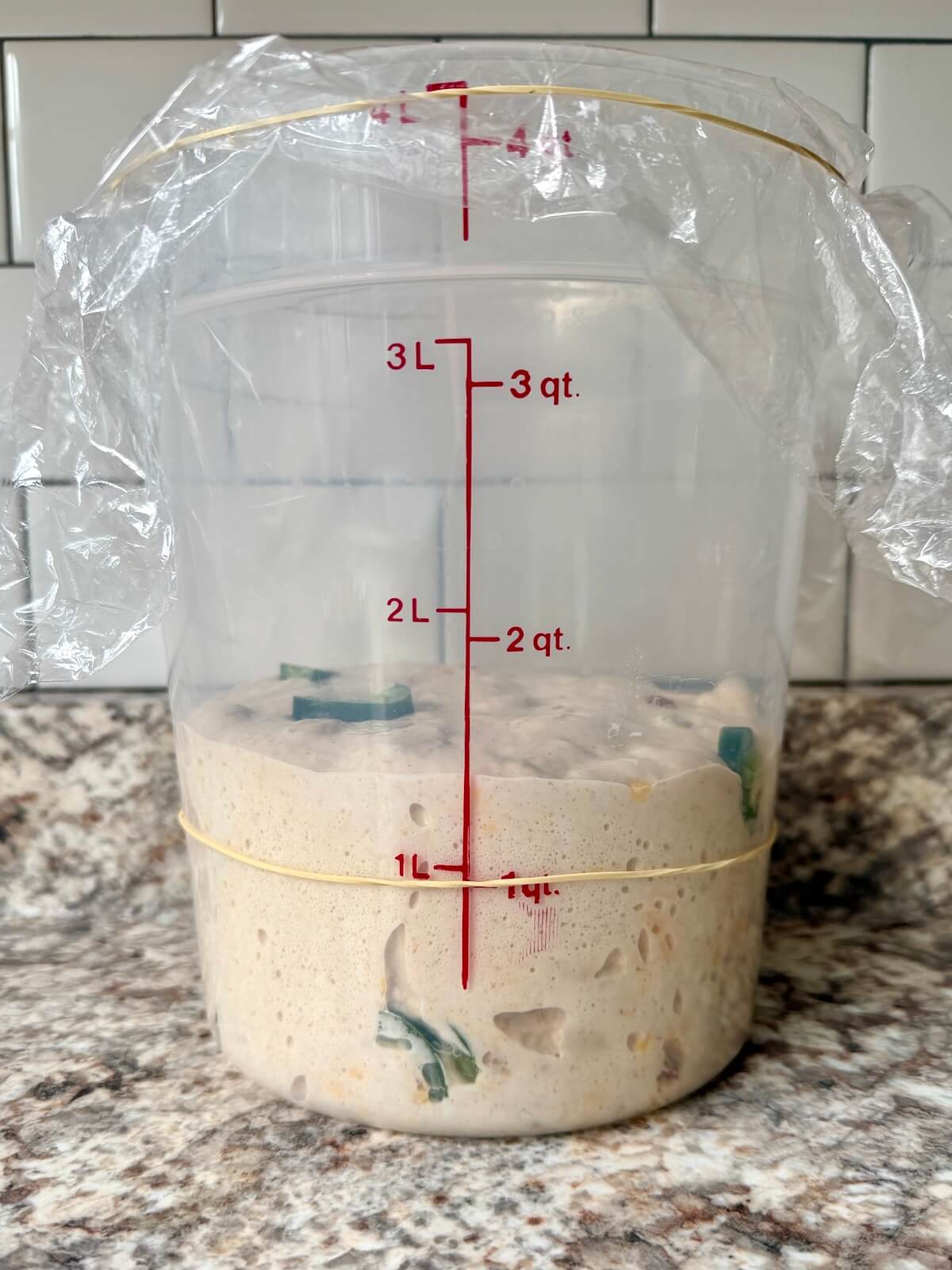 The dough in a straight-sided container after bulk fermenting.