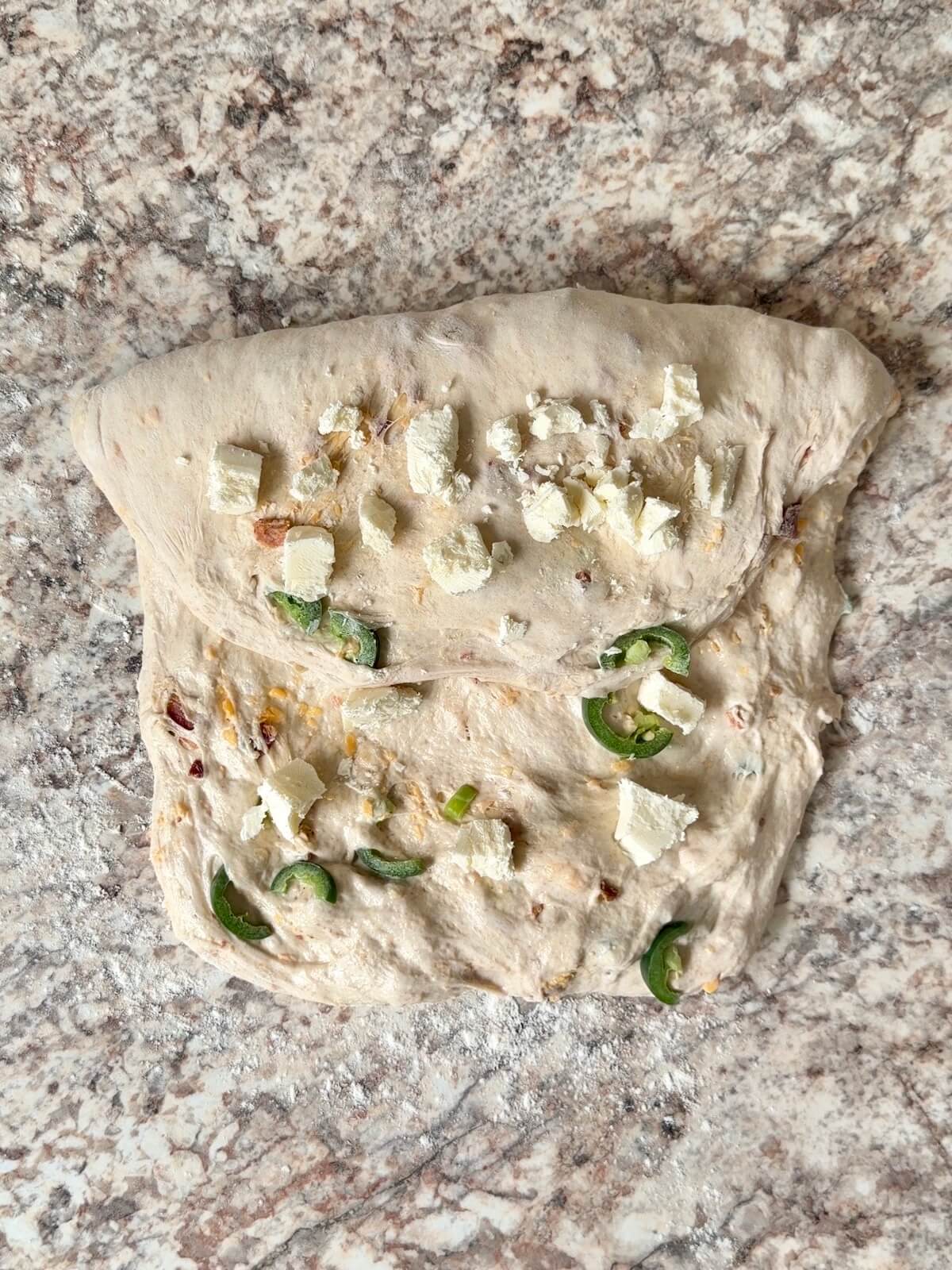 Cream cheese being added to the dough as it's being shaped.