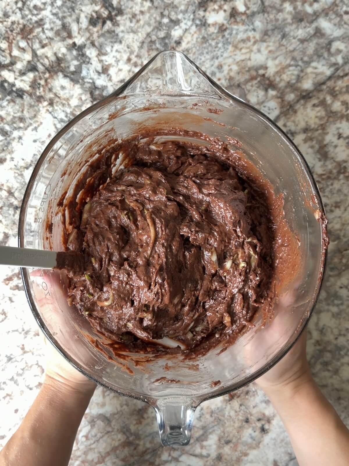 Sourdough chocolate zucchini bread batter whisked together in a bowl.