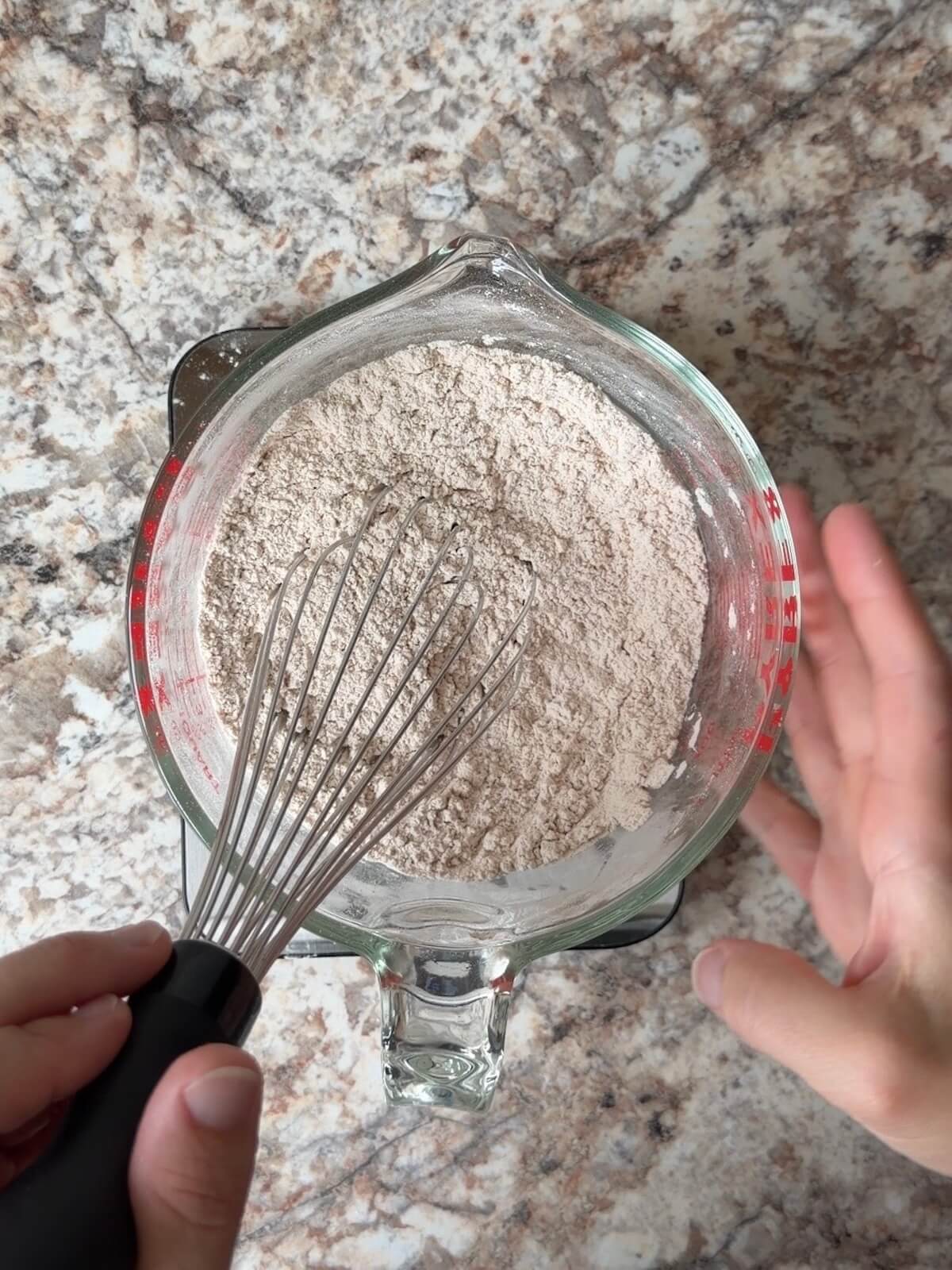 The dry ingredients being whisked in a glass bowl.
