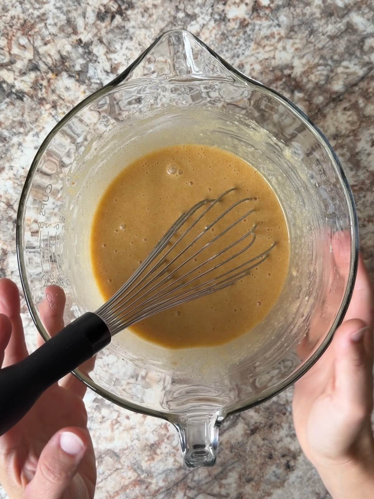 The wet ingredients, including sourdough discard, being whisked in a bowl.