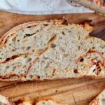 A slice of buffalo chicken sourdough bread on a wooden cutting board.