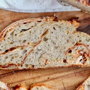 A slice of buffalo chicken sourdough bread on a wooden cutting board.
