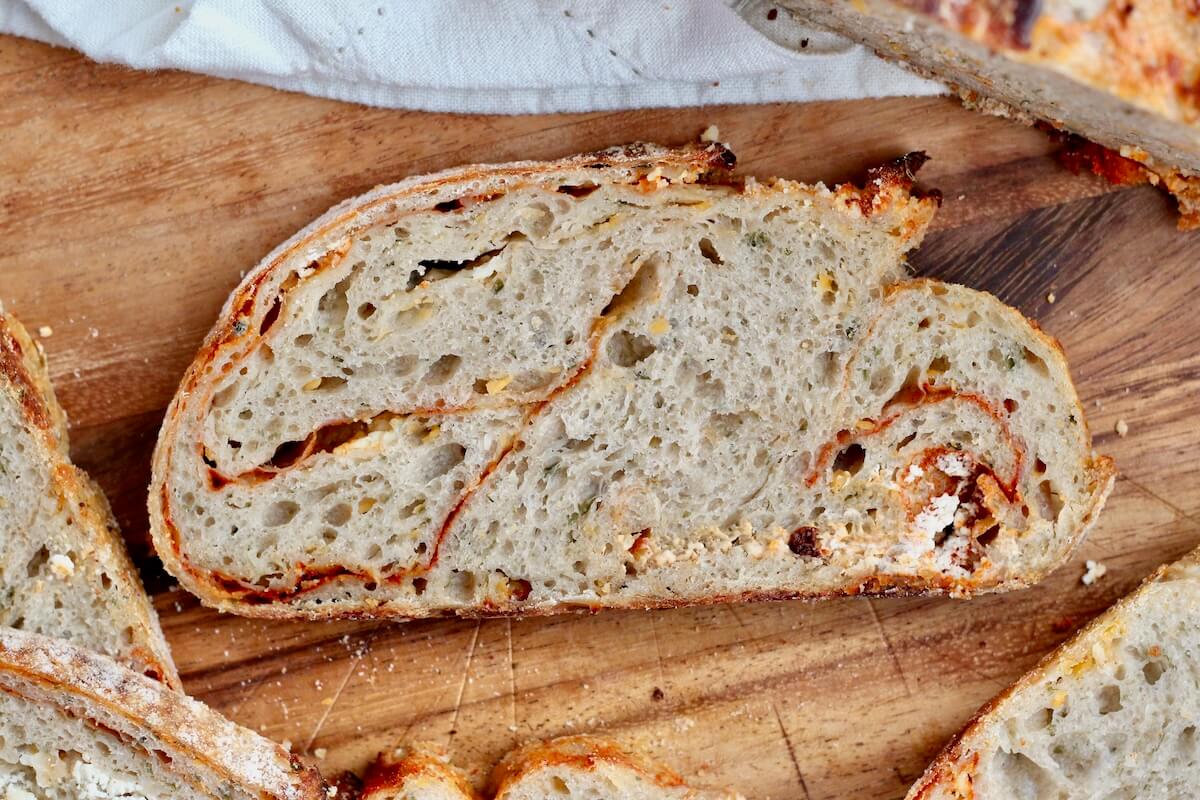 A slice of buffalo chicken sourdough bread on a wooden cutting board.