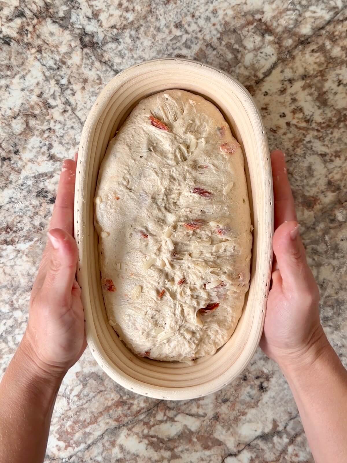 Pepperoni pizza sourdough bread in an oval proofing basket before cold proofing overnight.