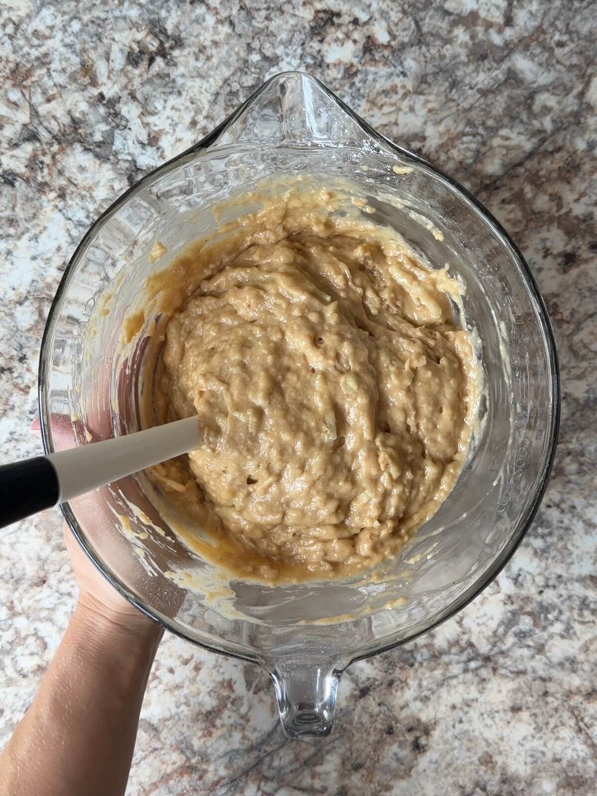 Sourdough apple muffin batter in a glass bowl.