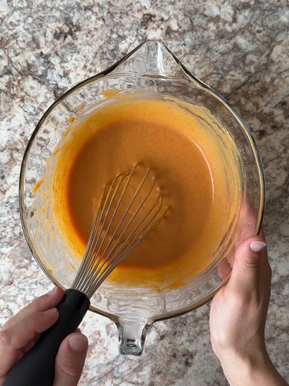 Sourdough discard, pumpkin puree, and other wet ingredients whisked together in a bowl.