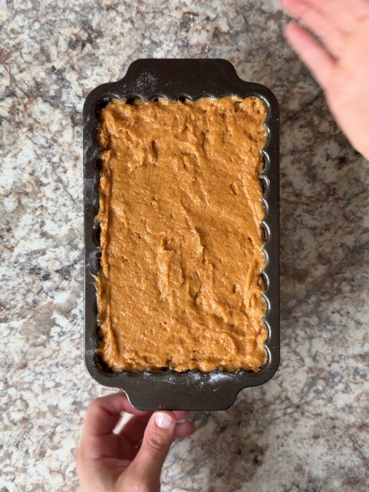 The sourdough pumpkin cream cheese bread batter in a loaf pan before baking.