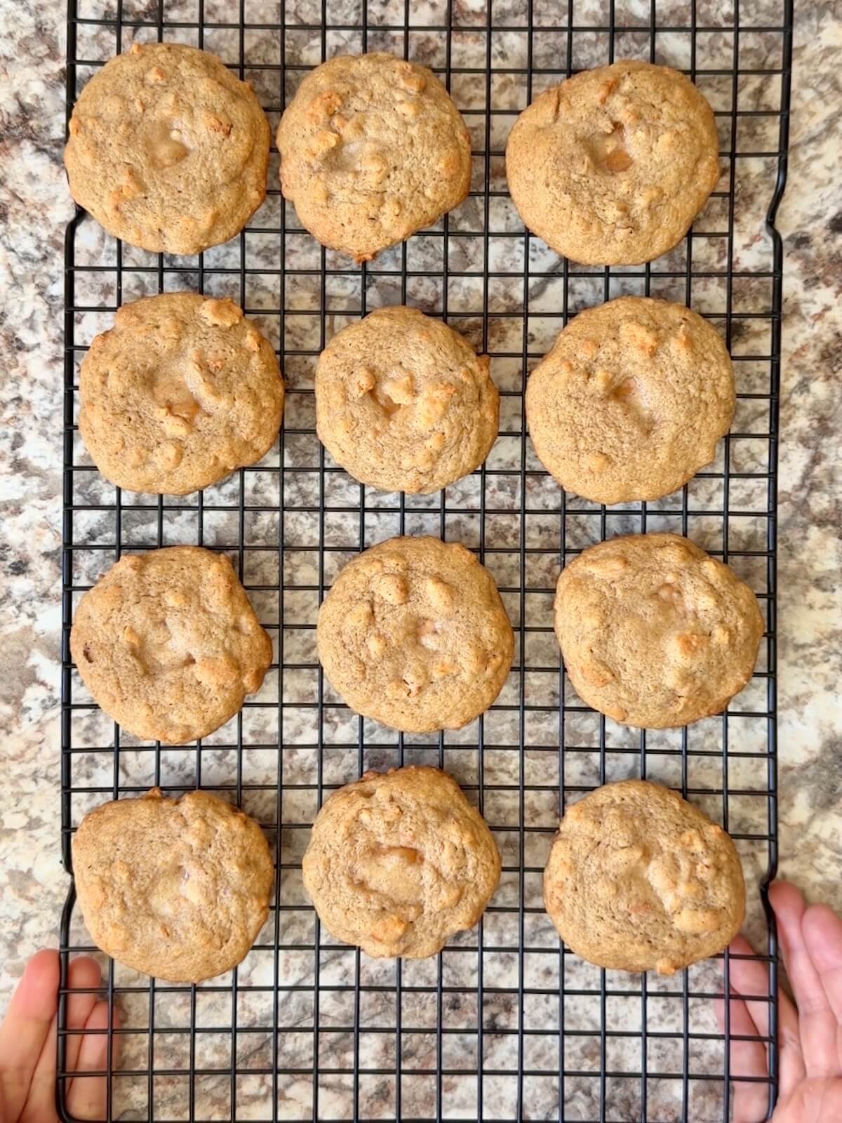 Caramel apple sourdough cookies cooling on a wire rack.