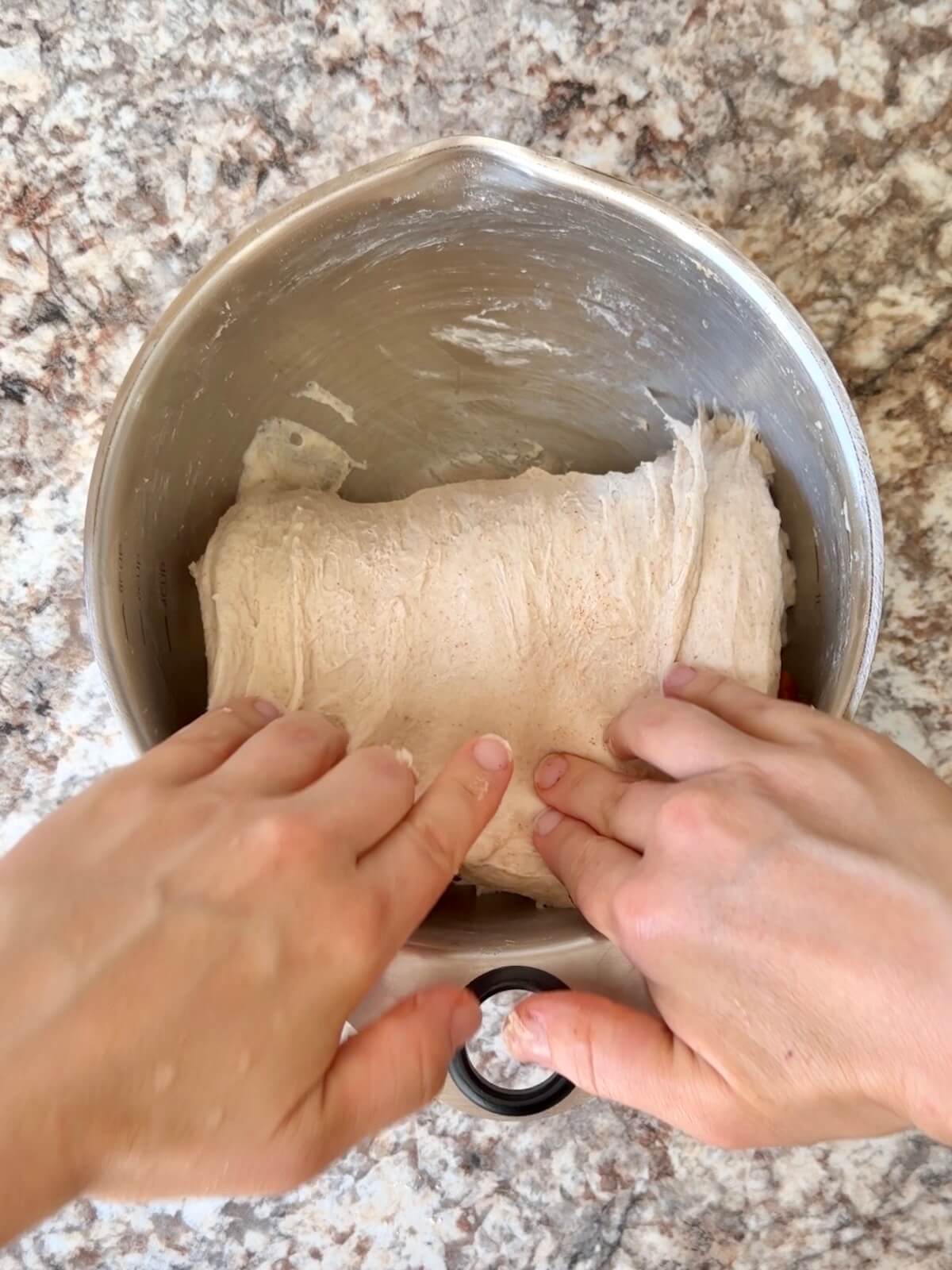 Sautéed cinnamon apples being stretched and folded into sourdough bread dough.