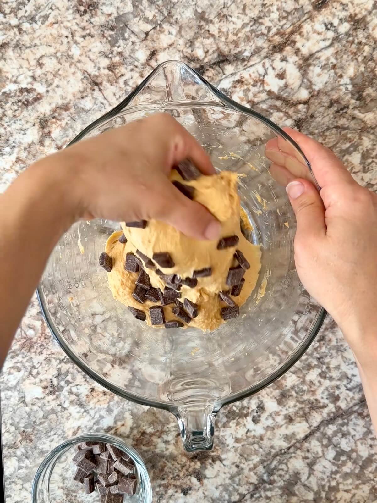 Semi-sweet chocolate chips being stretched and folded in to the pumpkin dough.