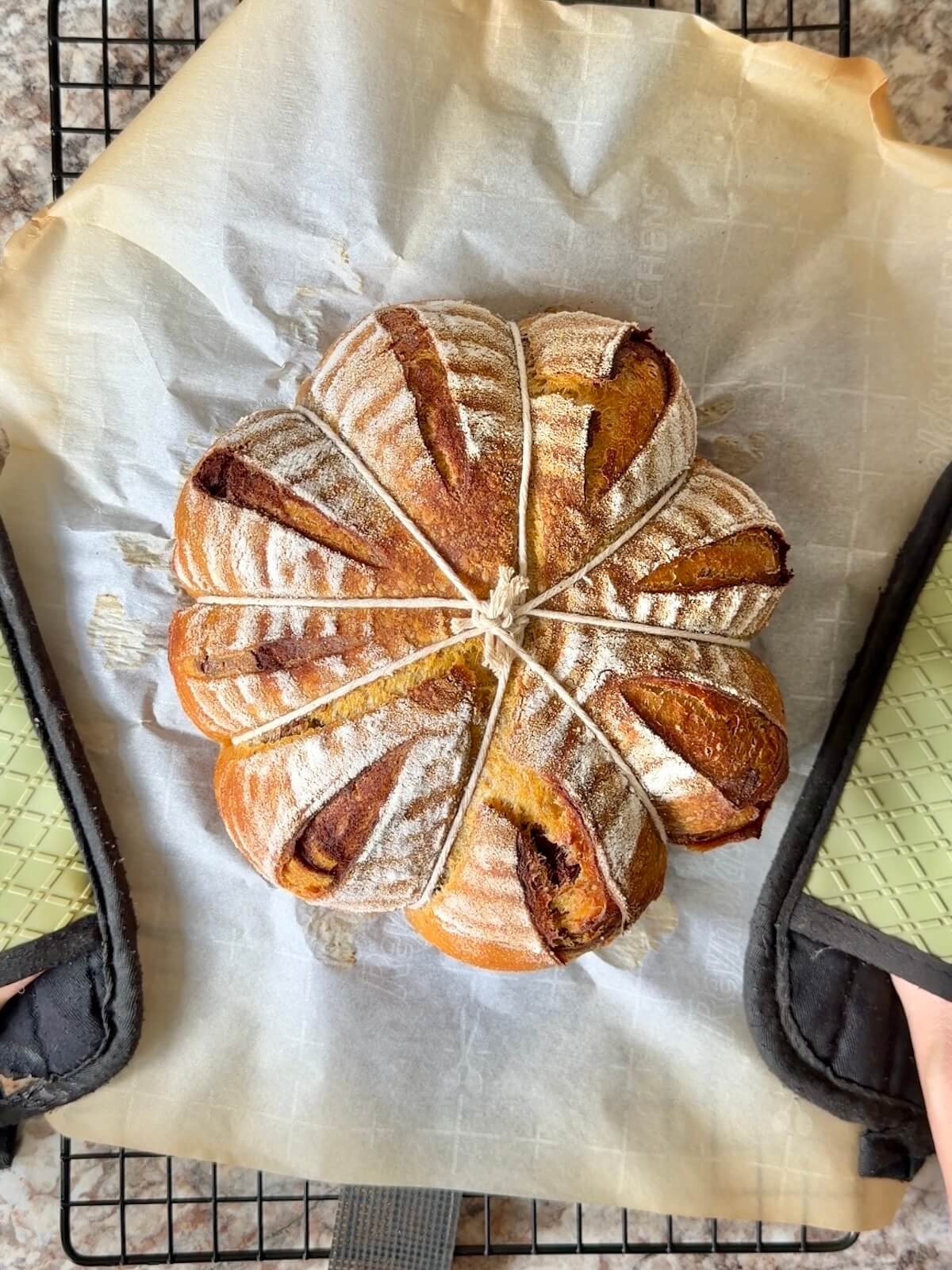 A baked loaf of pumpkin-shaped pumpkin spice sourdough bread.