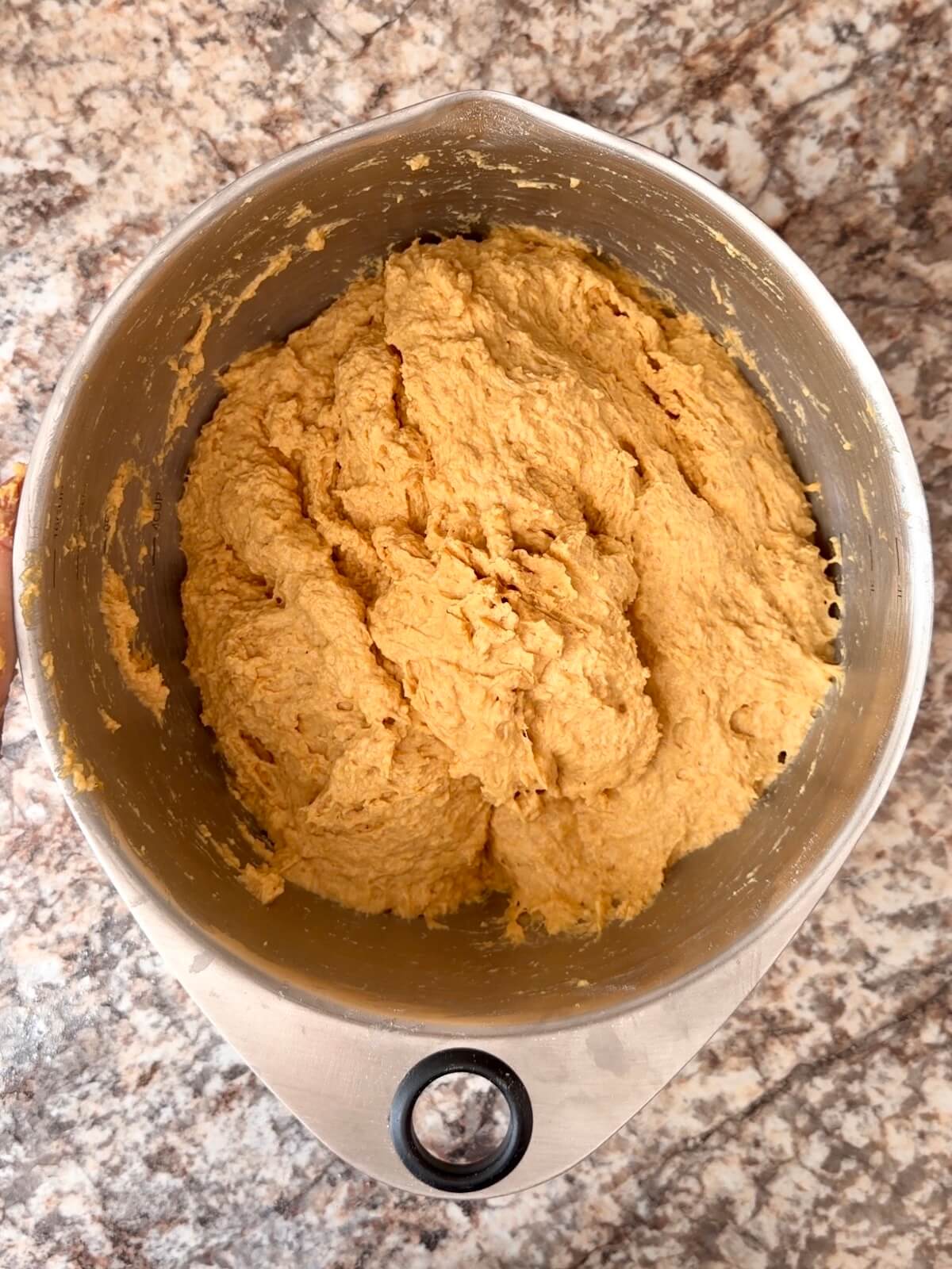 Pumpkin sourdough bread dough mixed together in a large mixing bowl.
