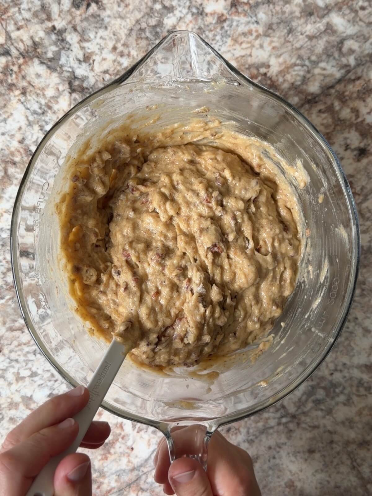 Brown butter sourdough banana bread batter with toasted pecans in a large bowl.