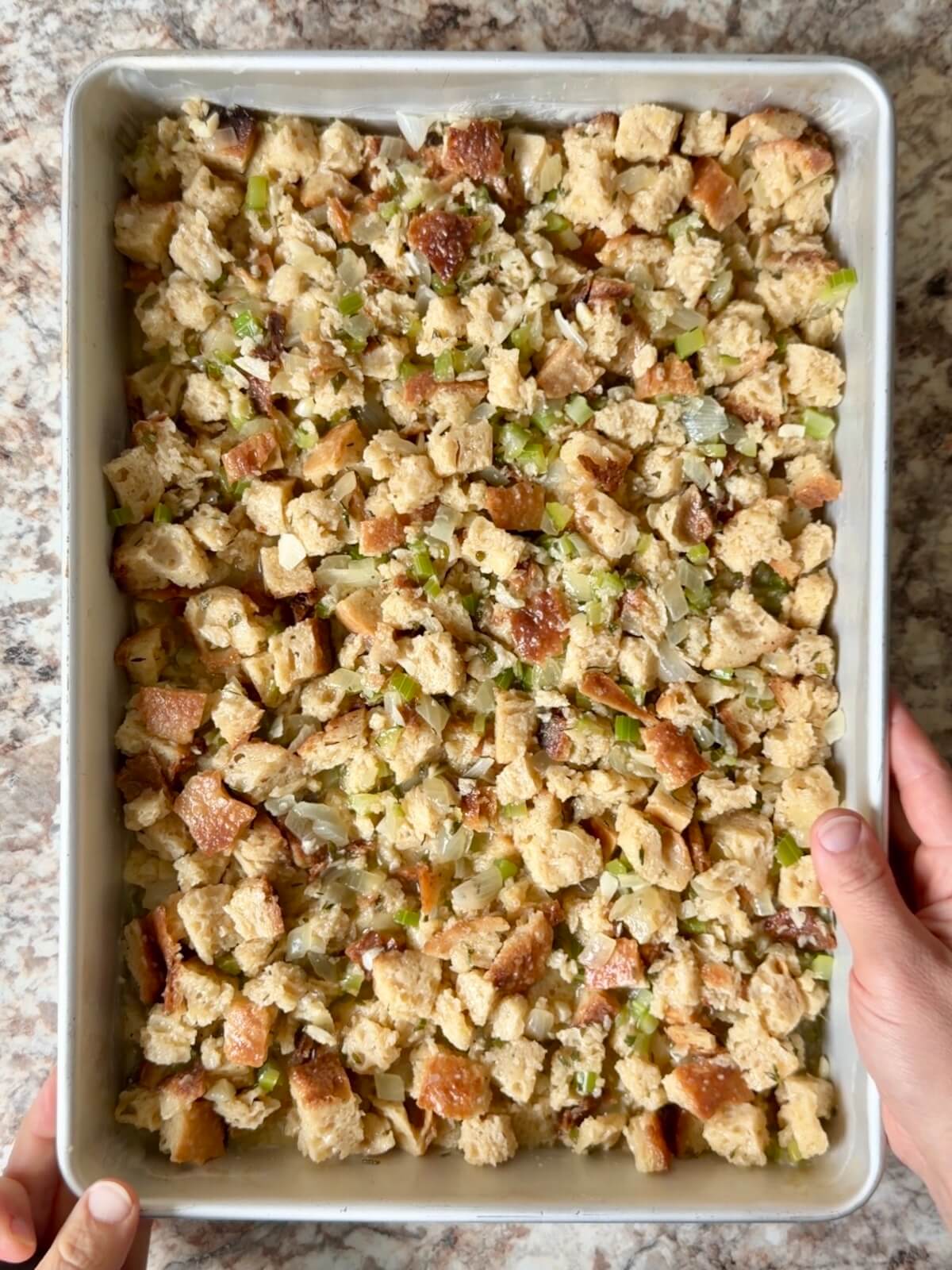 Sourdough bread stuffing in a buttered 9x13" pan before baking.