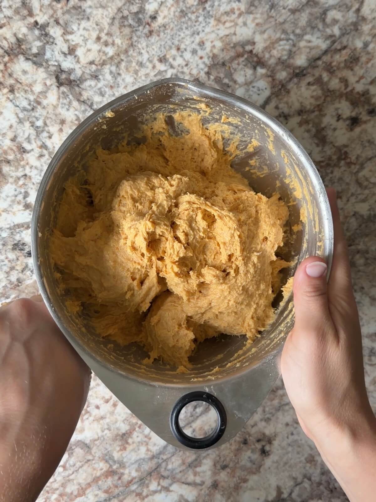 Sourdough pumpkin dinner roll dough in a mixing bowl.