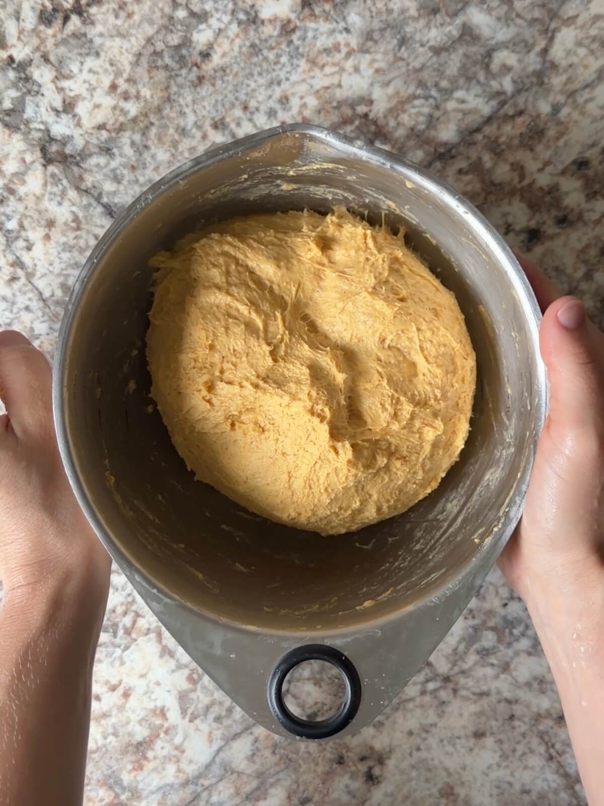 Sourdough pumpkin dinner roll dough in a mixing bowl after the first round of stretch and folds.
