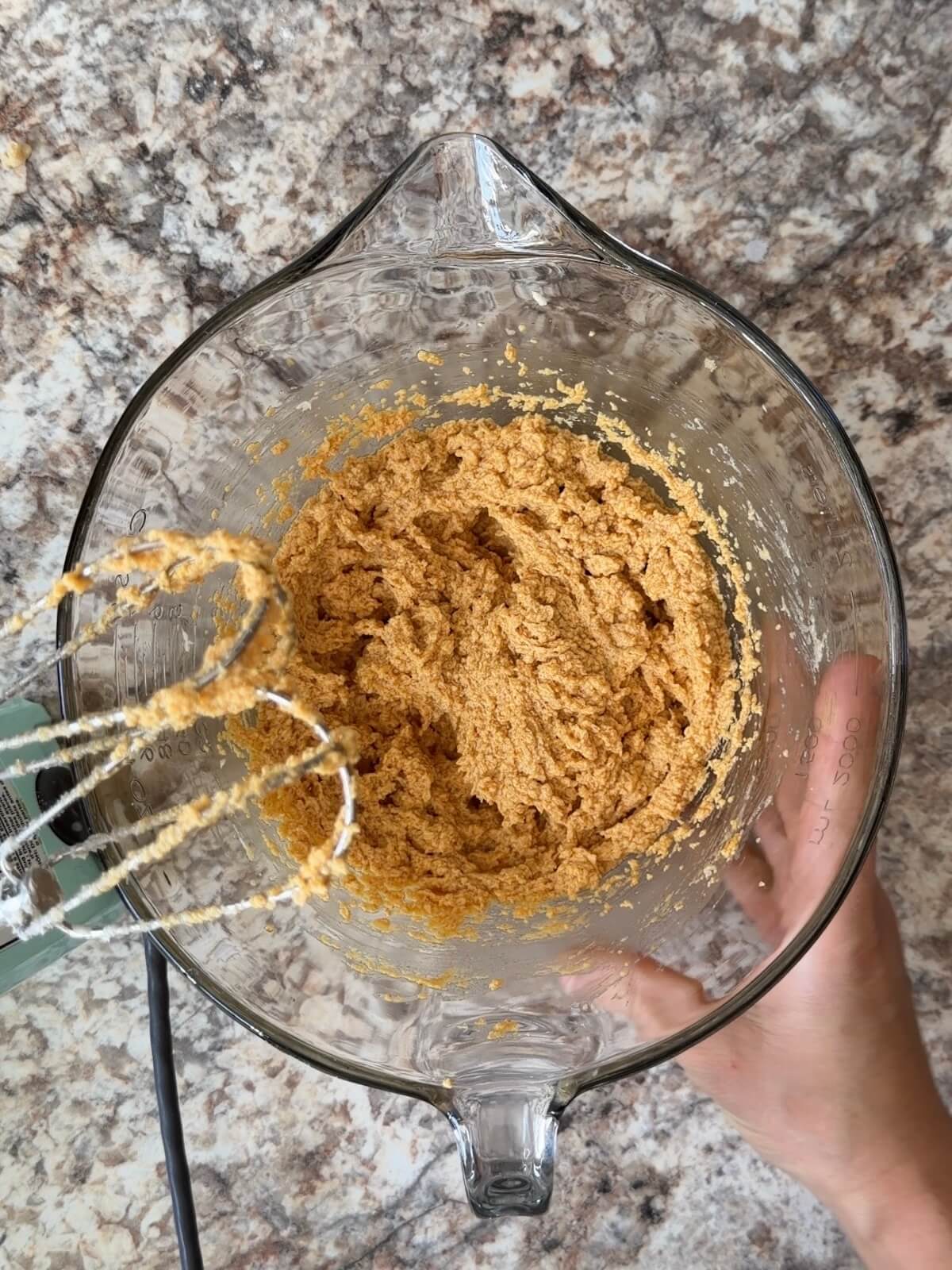 Pumpkin puree, sourdough discard, and other wet ingredients mixed together in a large glass bowl.