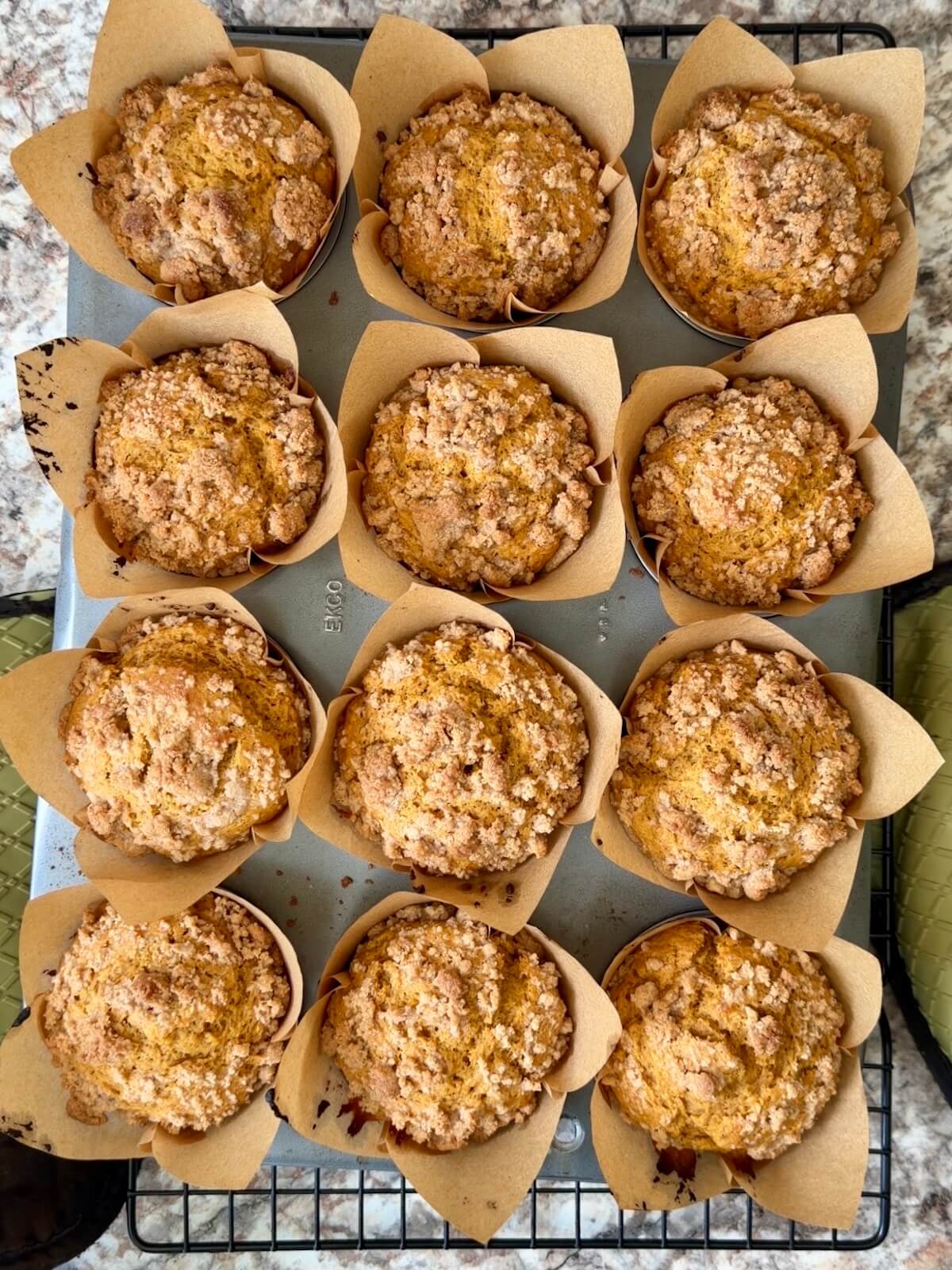 Baked sourdough pumpkin streusel muffins in a parchment lined muffin pan.