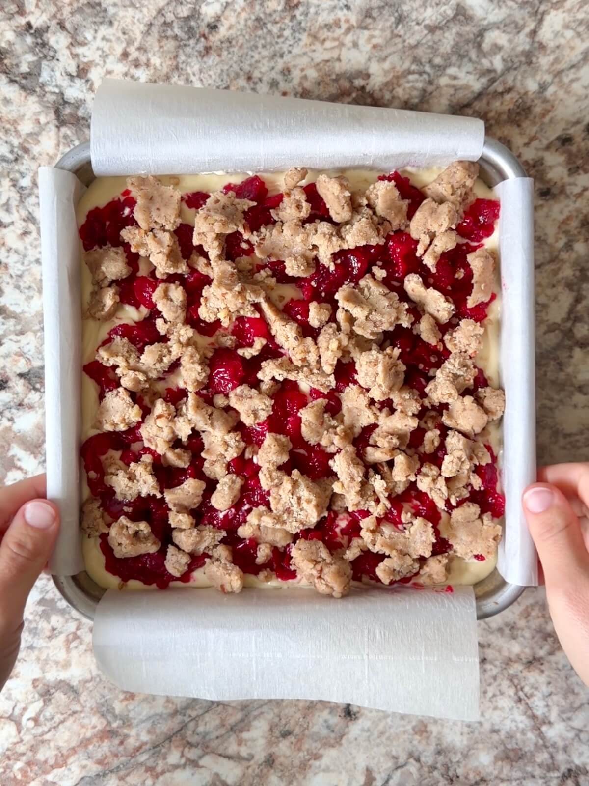 Pieces of pecan cookie dough spread on top of the cranberry jam layer.