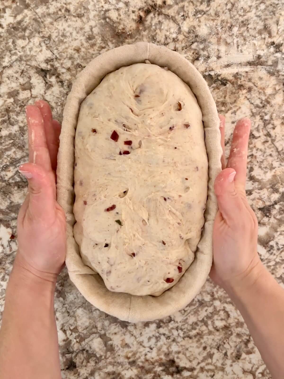 Thanksgiving stuffing sourdough bread in an oval proofing basket before cold proofing overnight.